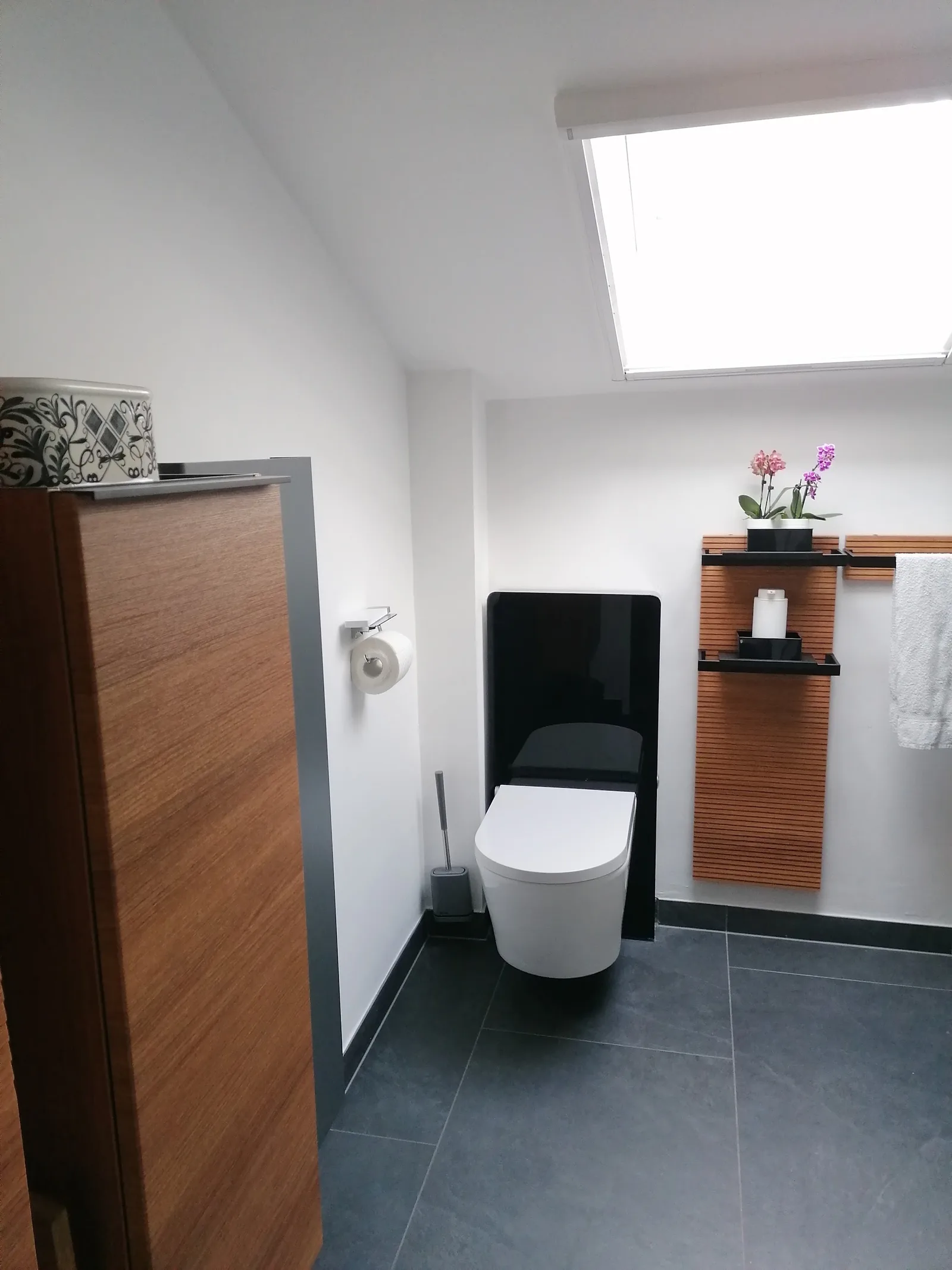 Fertiggestelltes Bad mit WC und Badmöbel unter einem Dachfenster